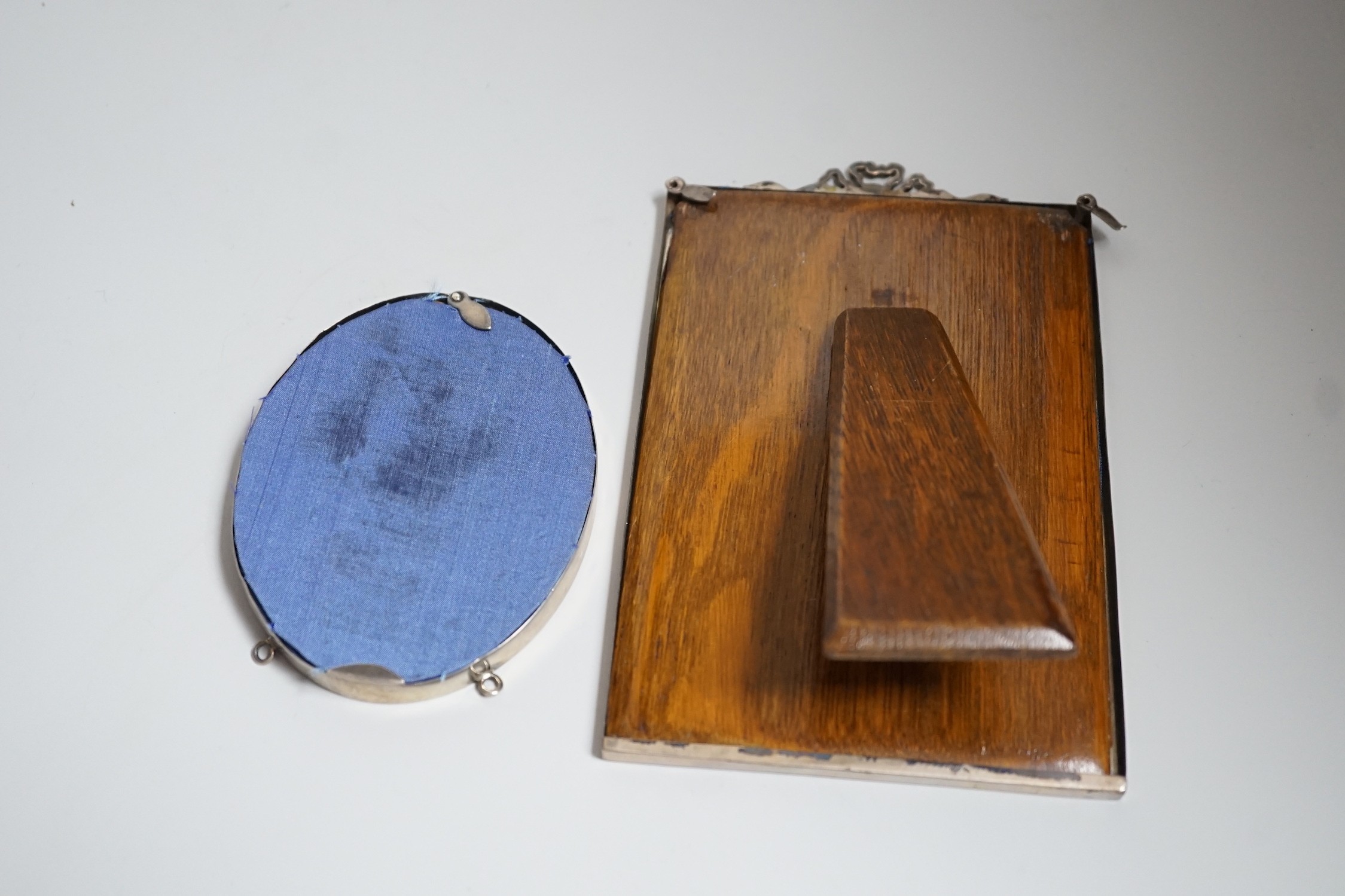 A George V silver mounted rectangular photograph frame, with ribbon bow crest, Birmingham, 1919, 16.1cm and an Edwardian silver mounted oval photograph frame by William Comyns, London, 1907.